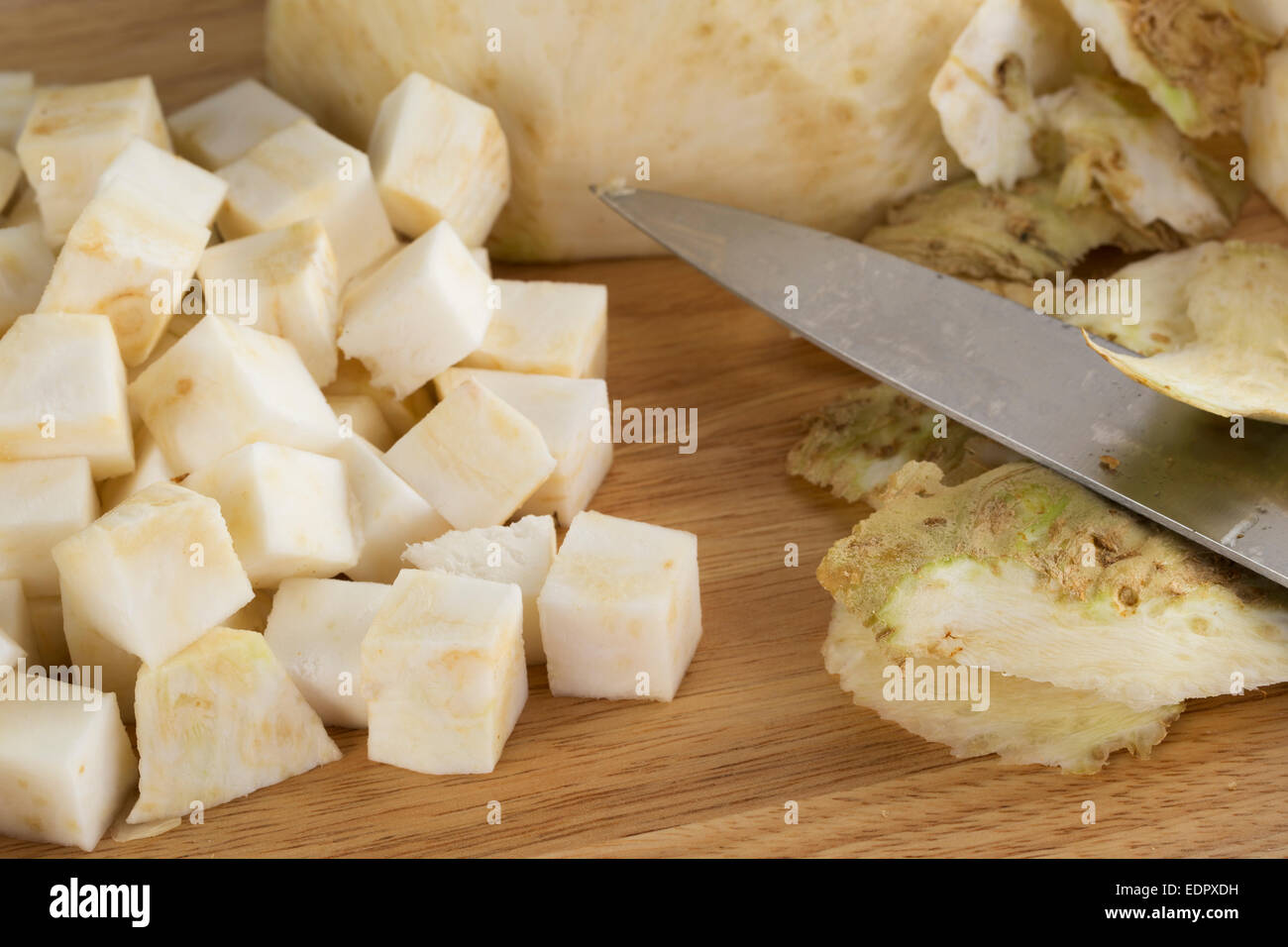 Celeriac cubes with peels and knife. Stock Photo