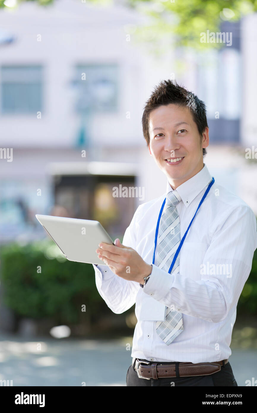 Businessman Holding Tablet Computer and Looking at Camera Stock Photo