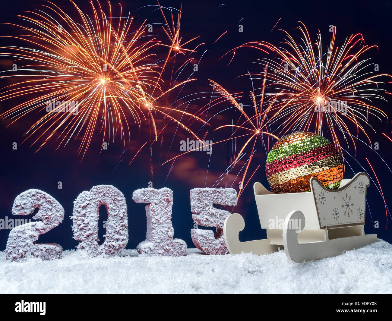 Frosted 2015 New Year digits and big glistering ball in wooden sleigh over dark blue sky with fireworks Stock Photo