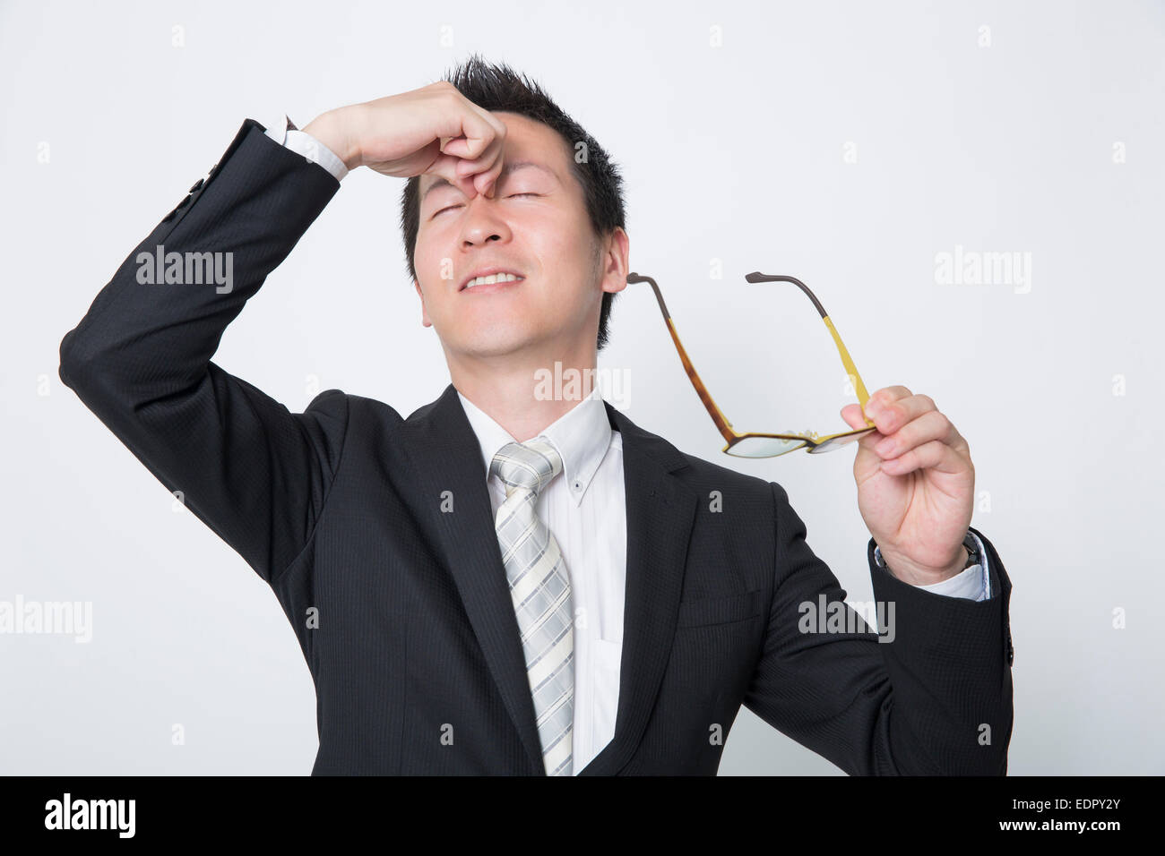 Tired Businessman Rubbing His Eyes Stock Photo