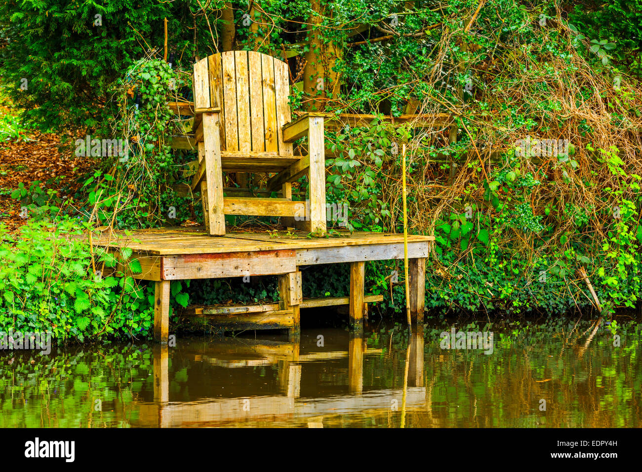 A canal in Kinver, West Midlands with a peaceful wooden seat for quiet contemplation or fishing. Stock Photo