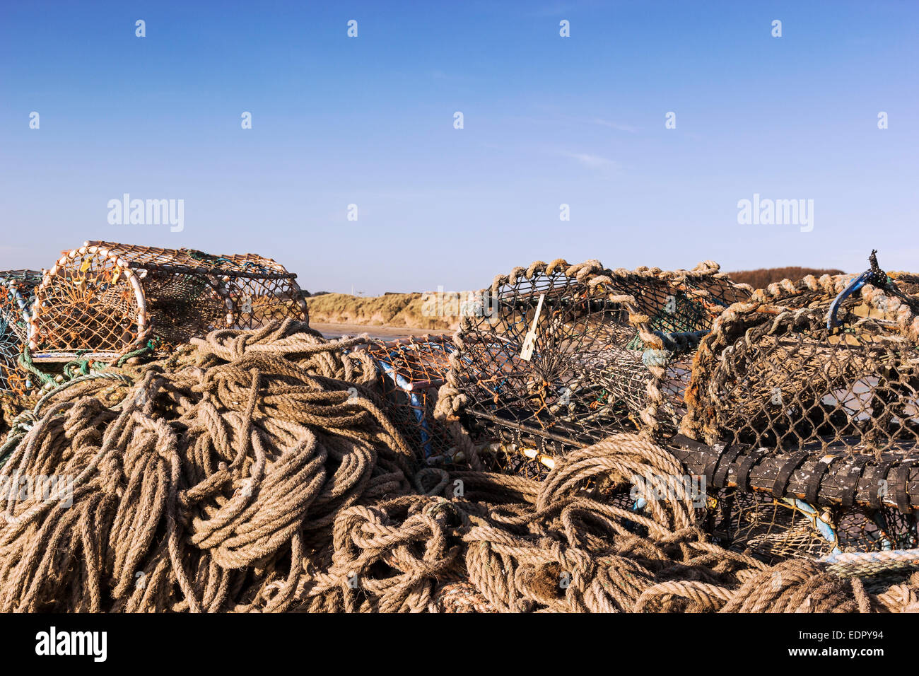 Lobster pots stacked on pier at Beadnell Bay, Northumberland Stock Photo