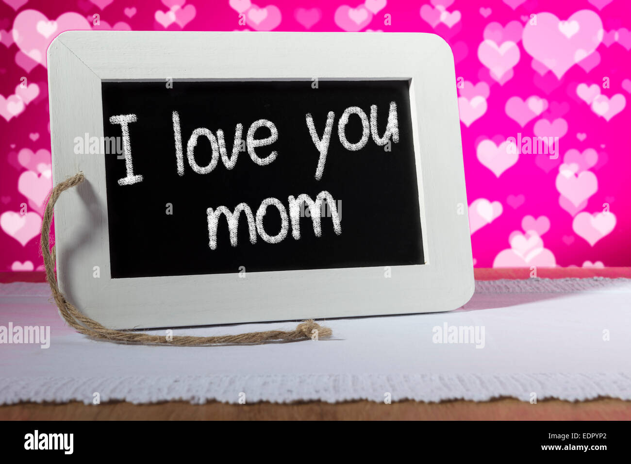 Image of a slate blackboard with chalk message I love you mom on pink background Stock Photo