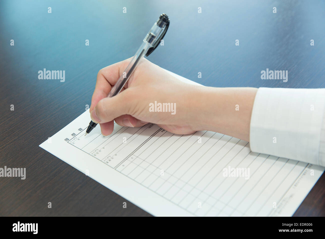 Woman Hand with Pen Filling out Job Application Stock Photo