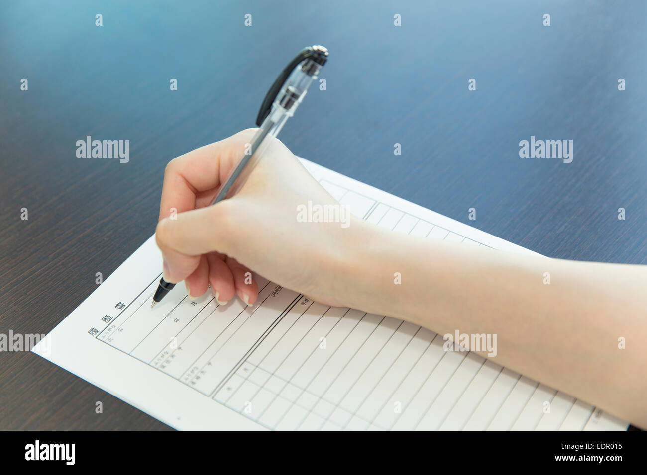 Woman Hand with Pen Filling out Job Application Stock Photo