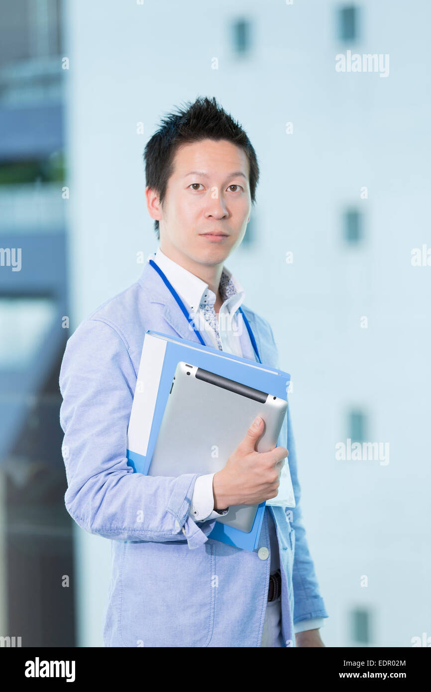 Businessman Holding Folder and Tablet Computer Stock Photo