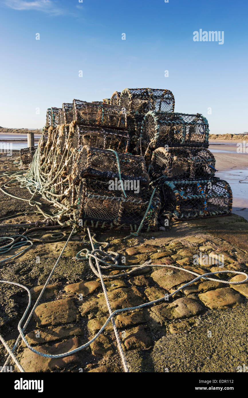 Lobster pots stacked on Beadnell Bay pier in Northumberland, UK Stock Photo