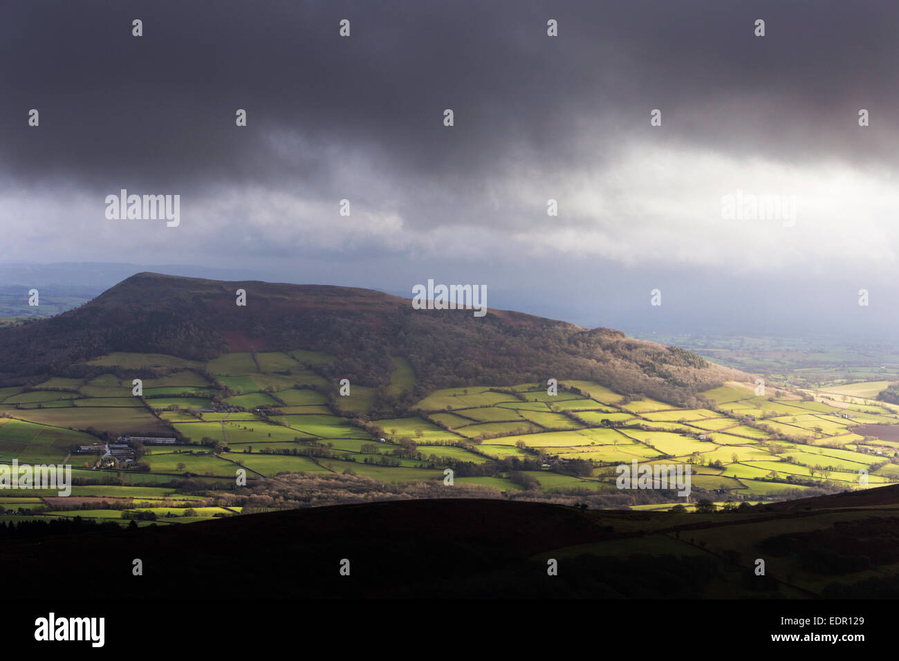 Looking across stormy skies towards Bryn Arw hill from the Suger Loaf