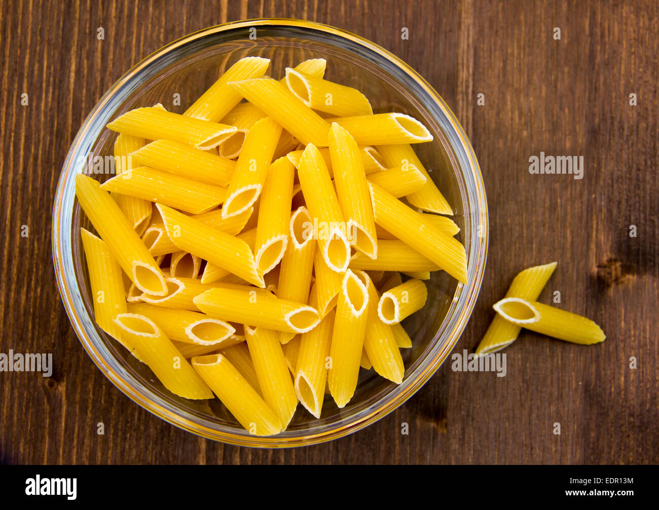 Glass bowl with pasta on the wooden table top view Stock Photo