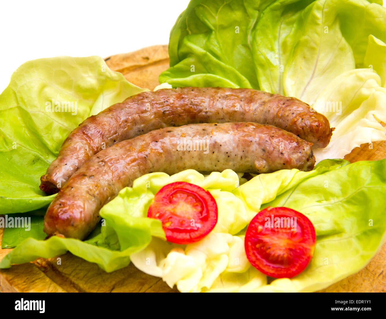 Sausage on wooden cutting board with salad Stock Photo