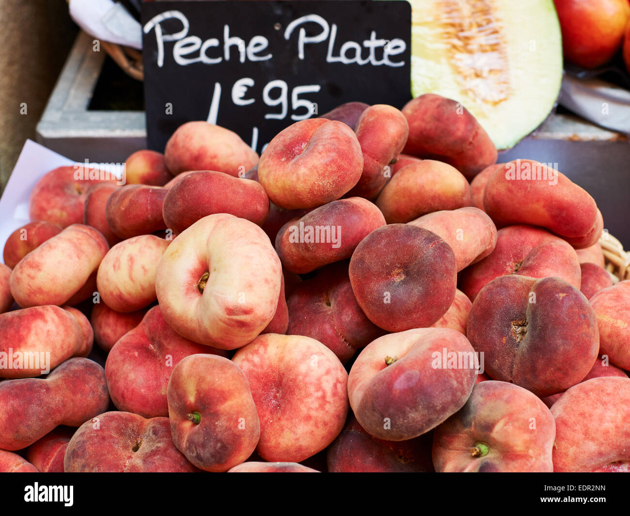 Red ripe flat peaches for sale on market stall in Provence, South France Stock Photo