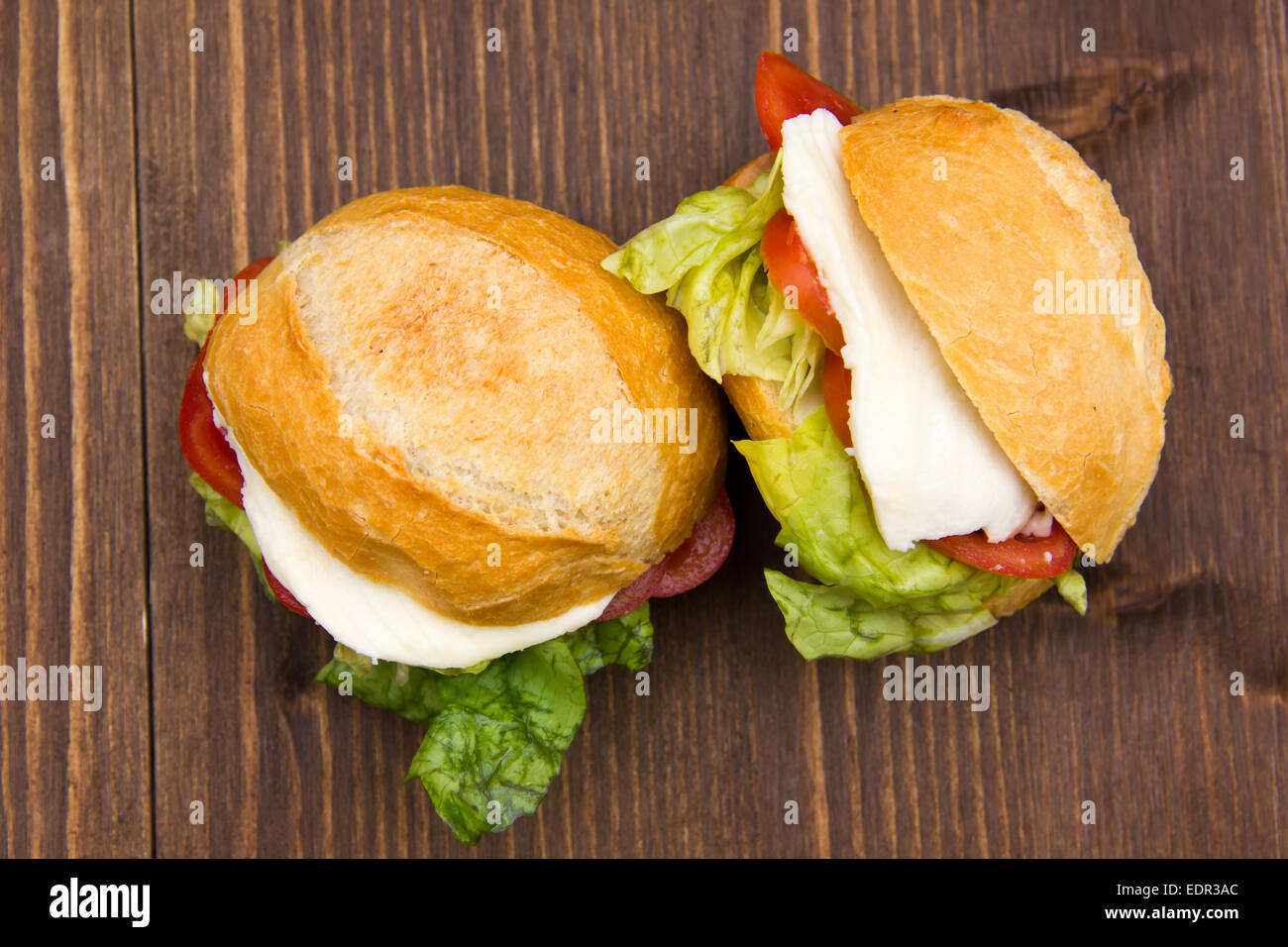 Sandwiches with cheese and tomatoes on wooden table seen from above Stock Photo