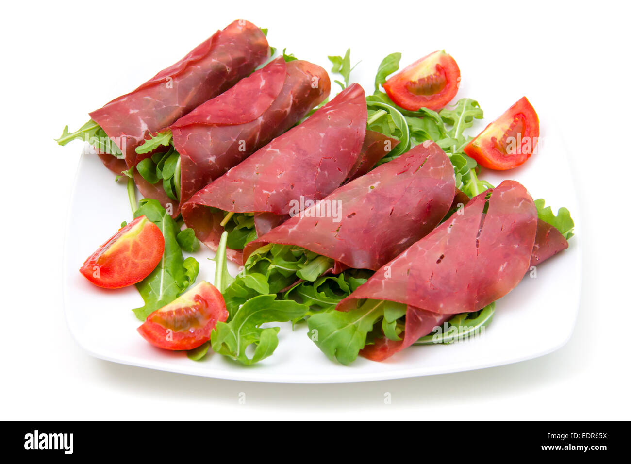 Rolls of dried beef on plate on white background Stock Photo