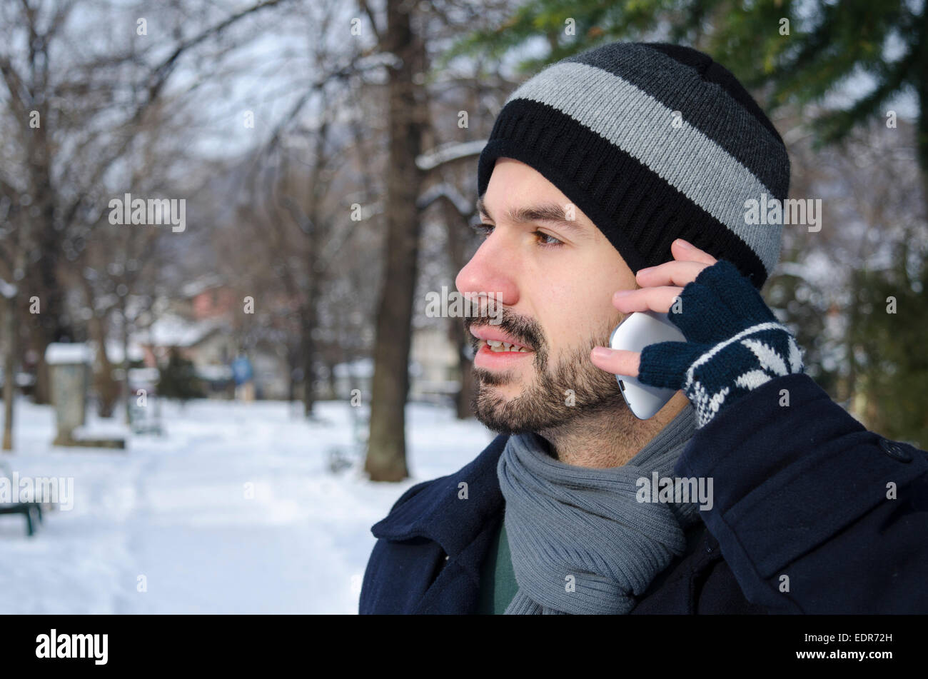 Bearded man talking on a cell phone in winter Stock Photo
