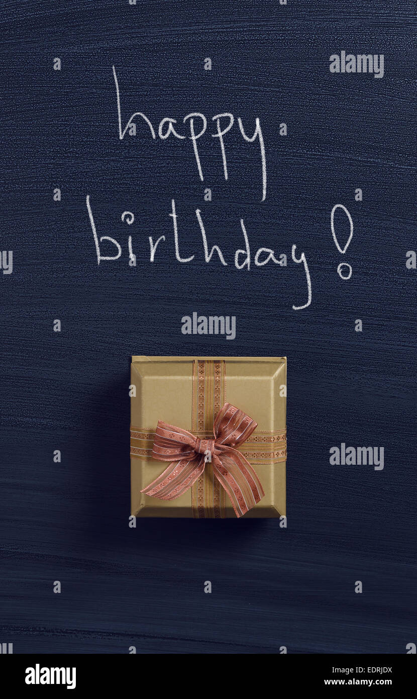 Gift box with 'Happy birthday!' handwritten on blackboard Stock Photo