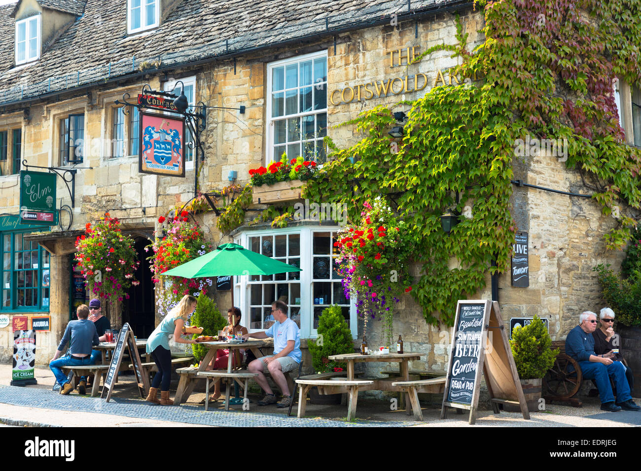 Tourists drinking at The Cotswolds Arms inn traditional old gastro pub  in Burford in The Cotswolds, Oxfordshire, UK Stock Photo