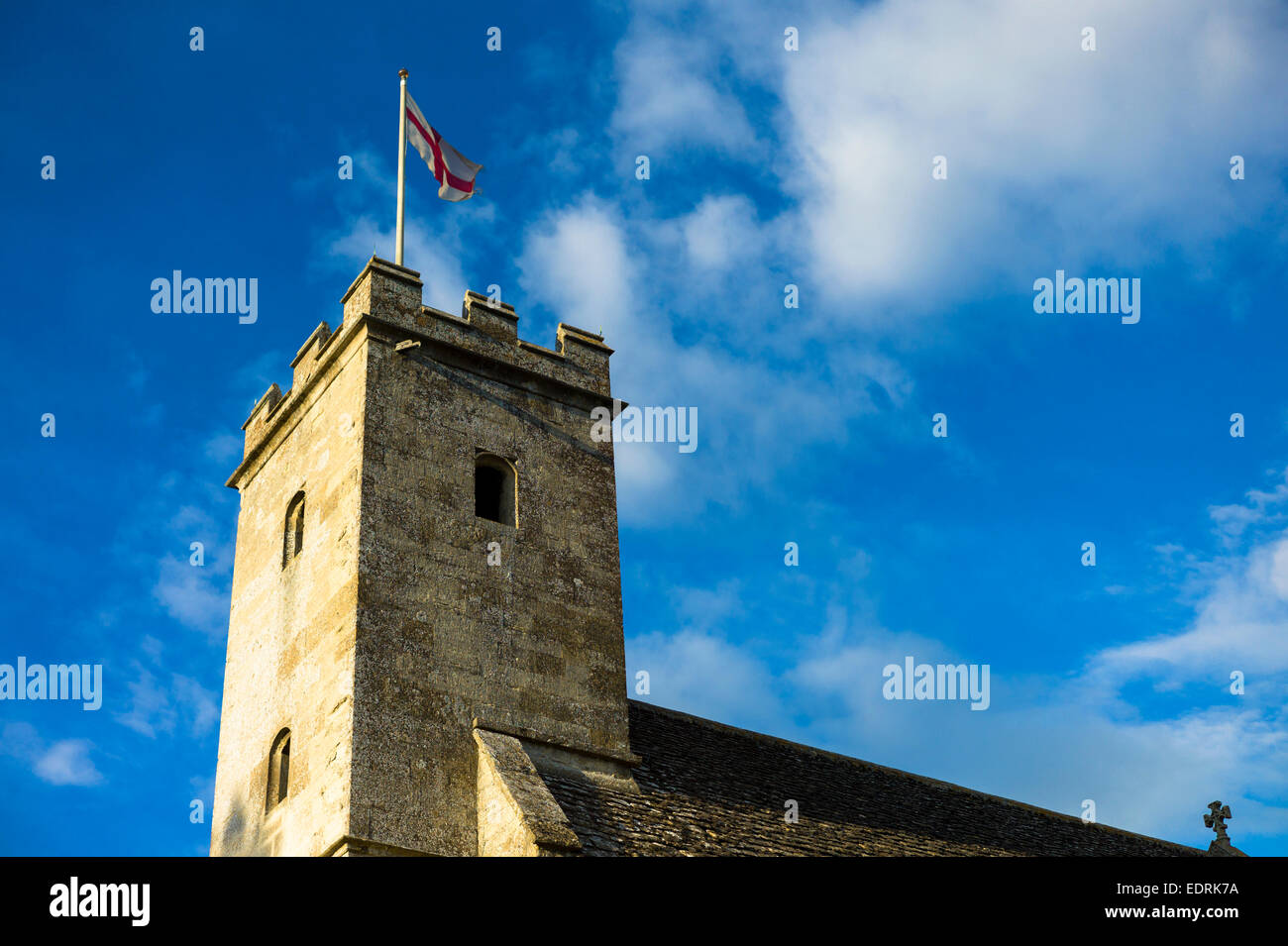 English flag of St George on old stone tower of St Mary's Church, Swinbrook, The Cotswolds, England, UK Stock Photo