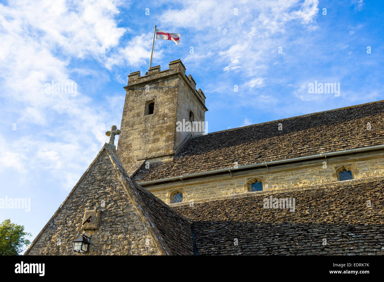 English flag of St George on old stone tower of St Mary's Church, Swinbrook, The Cotswolds, England, UK Stock Photo