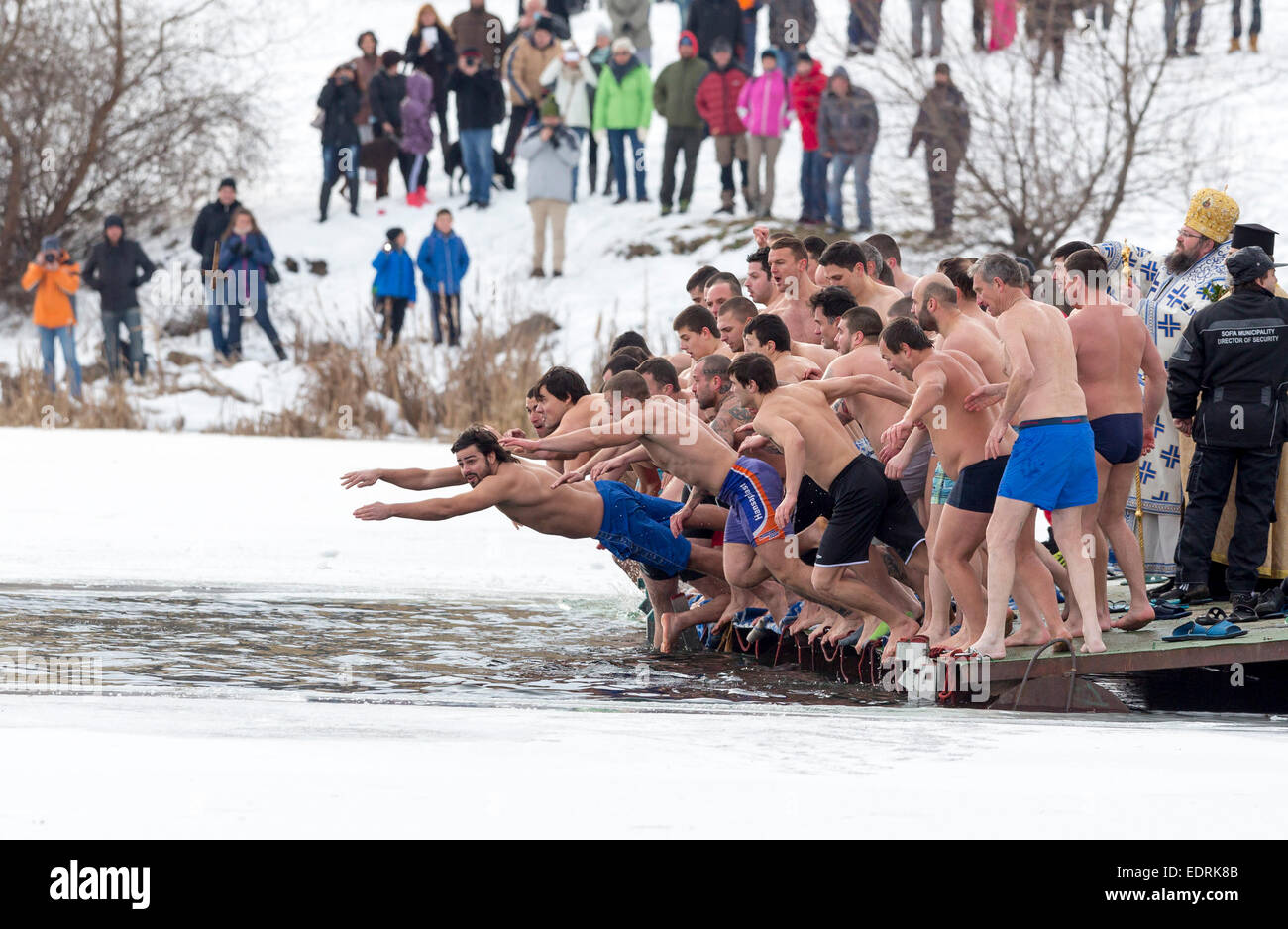 Sofia, Bulgaria - January 6, 2015: Men are jumping into a frozen lake waters for a wooden cross at Epiphany day celebration in B Stock Photo