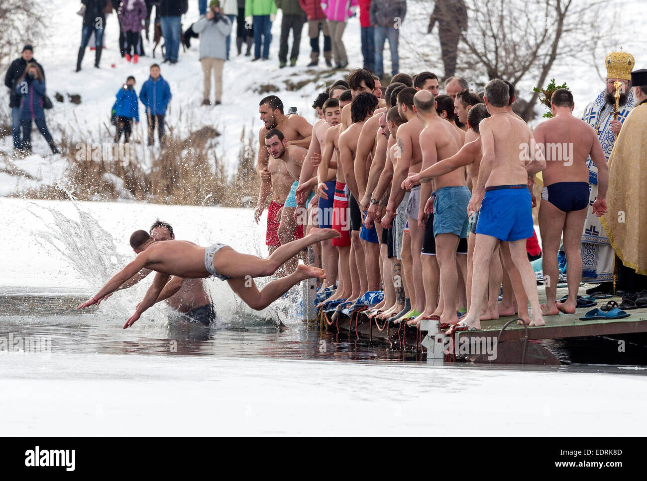 Sofia, Bulgaria - January 6, 2015: Men are jumping into a frozen lake waters for a wooden cross at Epiphany day celebration in B Stock Photo