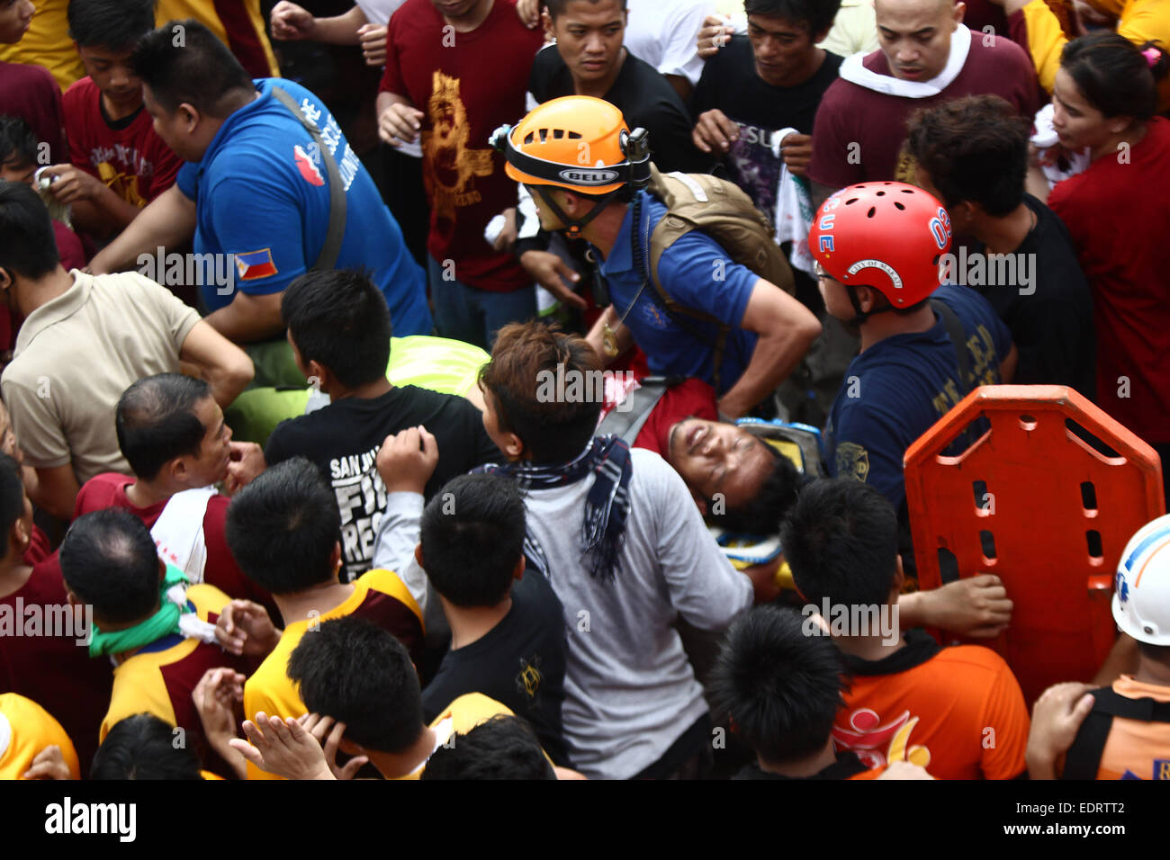 Manila, Philippines. 9th Jan, 2015. People carry an unconscious fellow devotee after he fainted during the annual feast of the Black Nazarene in Manila, the Philippines, Jan. 9, 2015. One person died and dozens injured while about 500,000 people participated in the procession that started in Manila's Rizal Park. Credit:  Rouelle Umali/Xinhua/Alamy Live News Stock Photo