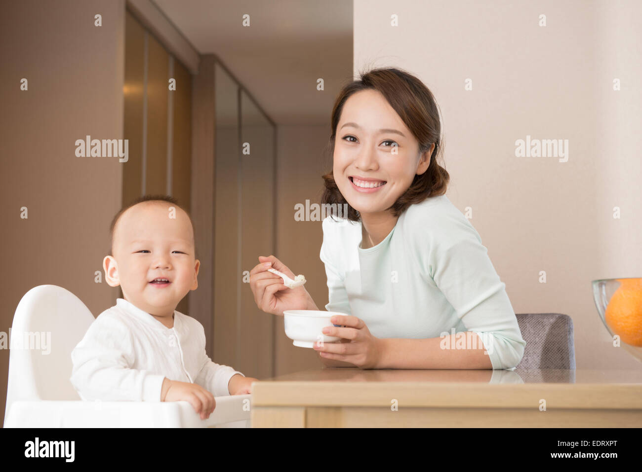 Young mother feeding baby boy Stock Photo