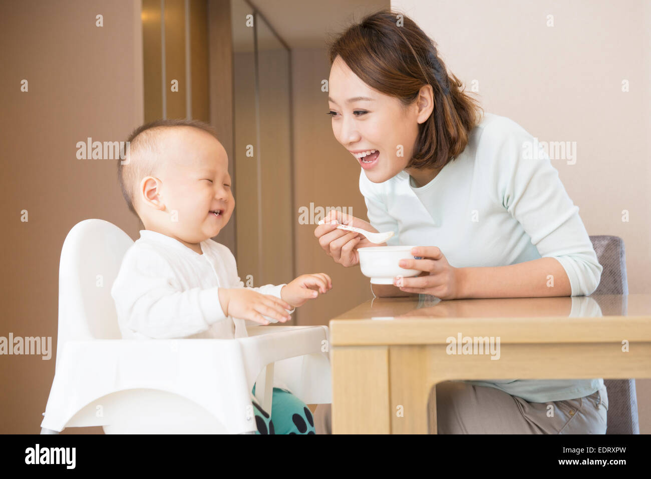 Young mother feeding baby boy Stock Photo
