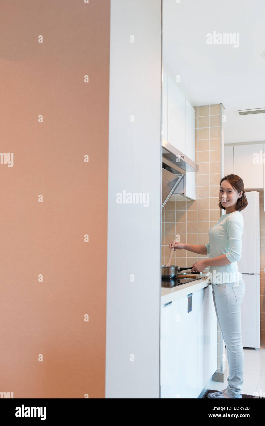 Young woman cooking in kitchen Stock Photo