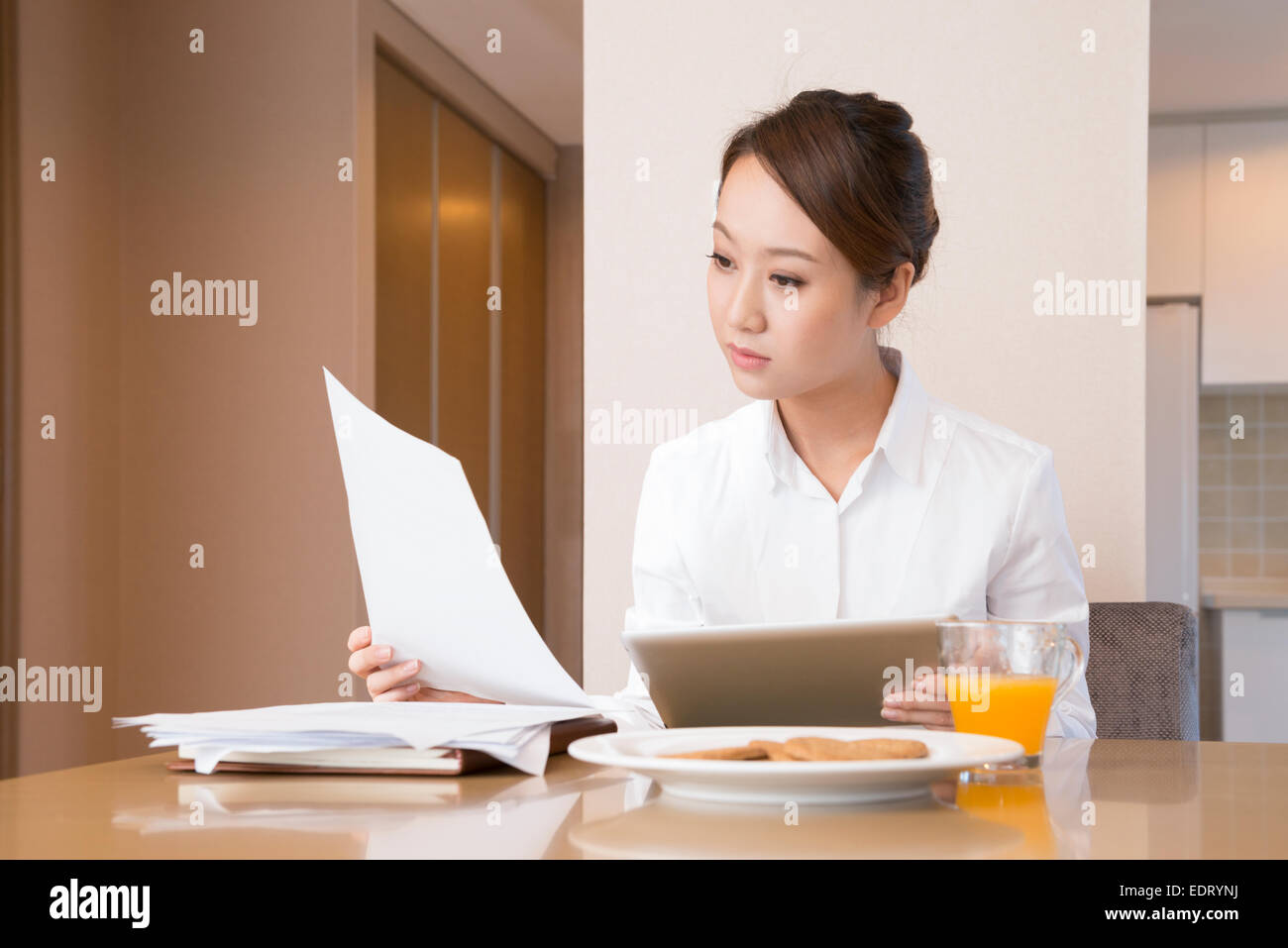 Young woman using tablet at breakfast Stock Photo