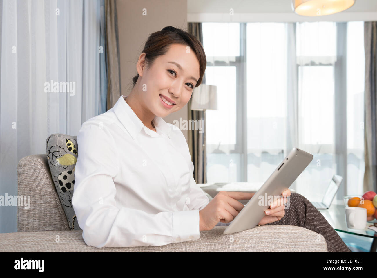 Young woman using tablet in living room Stock Photo