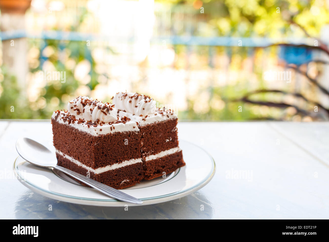 chocolate cakes with white cream on top and spoon on plate in house and ...