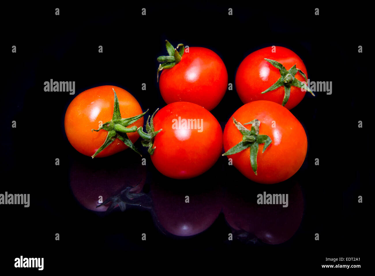 Cherry tomato that is reflected on a black background Stock Photo - Alamy