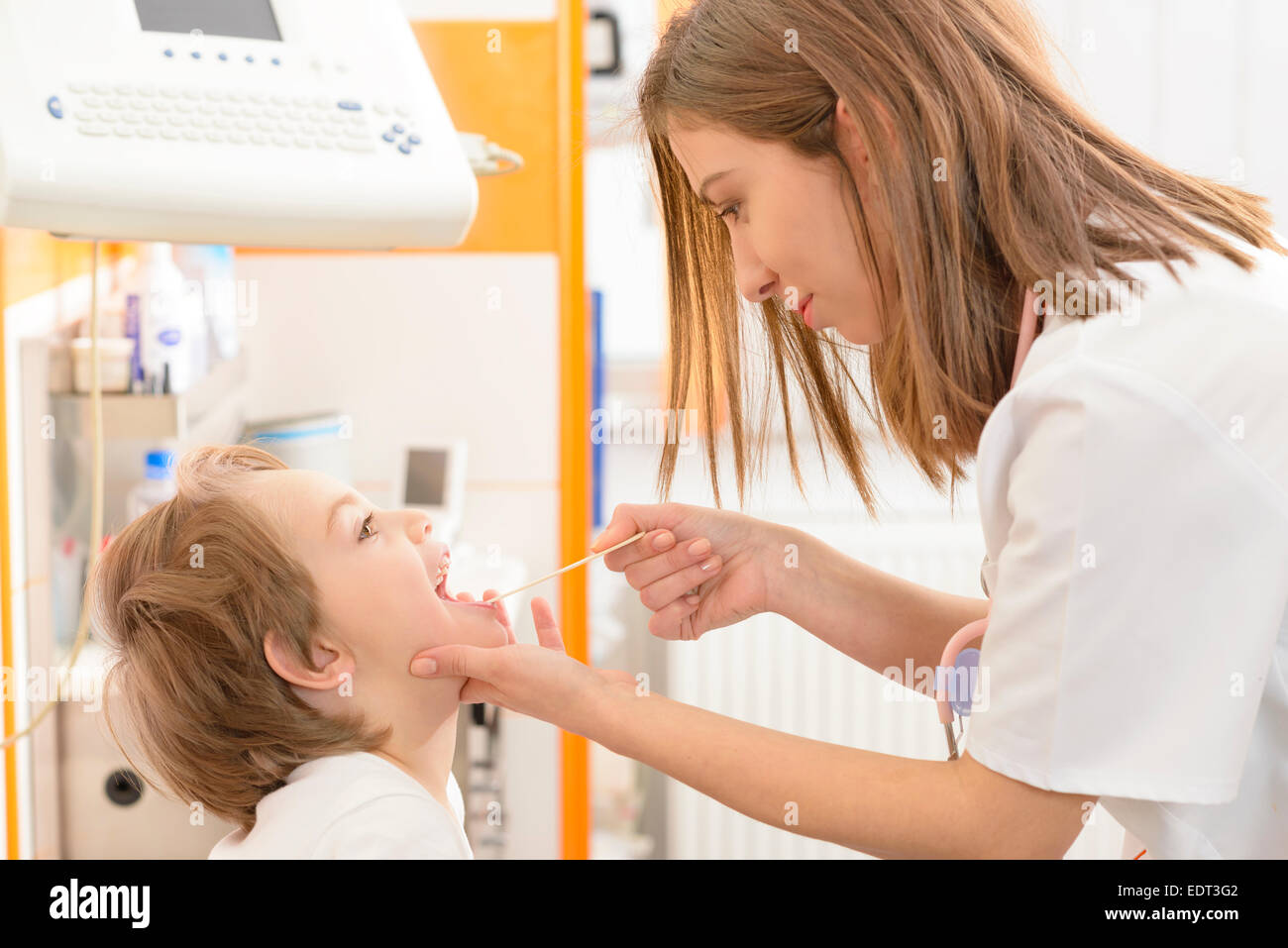 Cute boy being checked in throat in a clinic Stock Photo