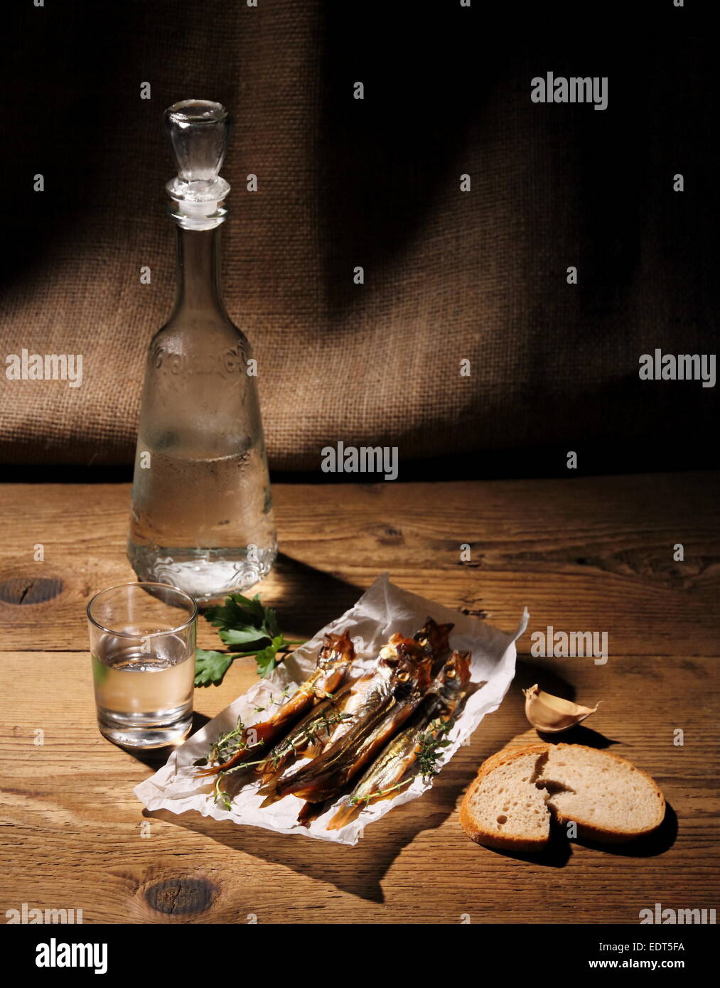 Glass of vodka with dried capelin and bread, vertical Stock Photo