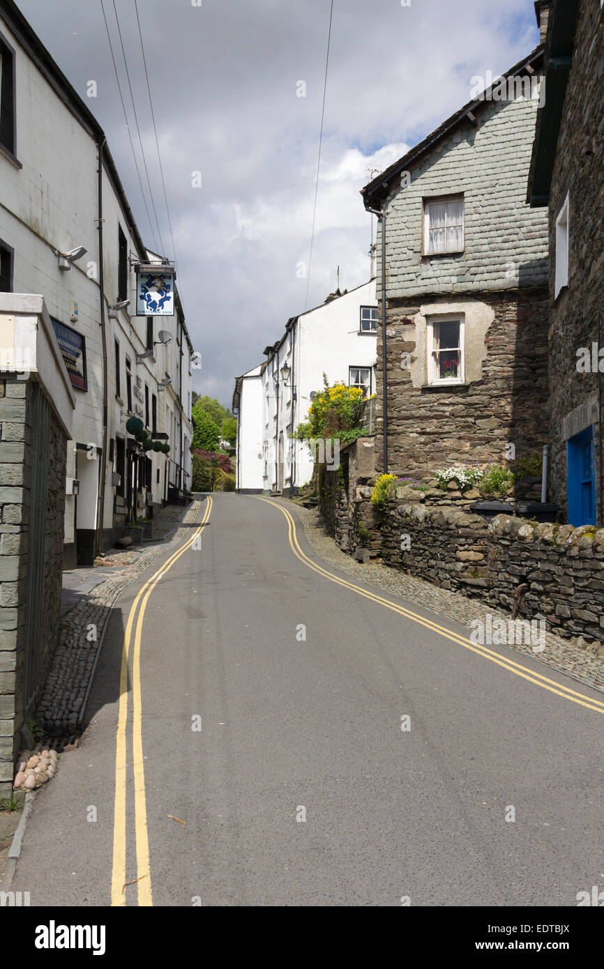 Ambleside in the Lake District with North Road, a narrow town road, lined with stone-built and whitewashed houses and a pub, close to the town centre. Stock Photo
