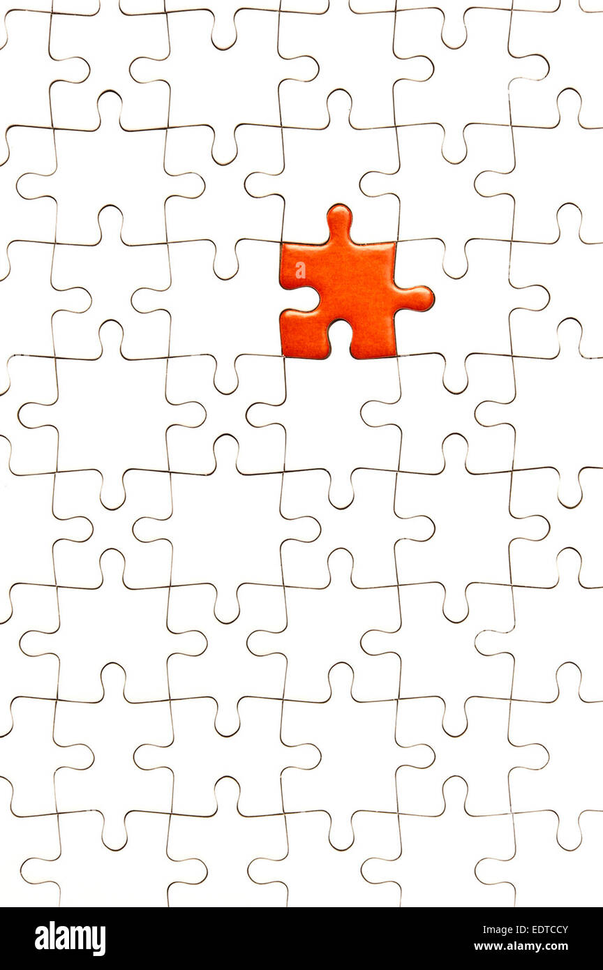 white jigsaw puzzle with one piece red Stock Photo