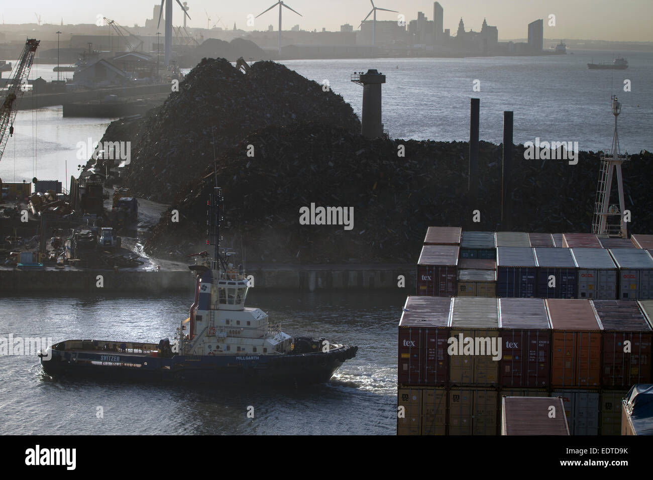A tug pulling the Panama-registered container ship MSC Sandra, at the Seaforth Docks, Liverpool, England, UK. Stock Photo