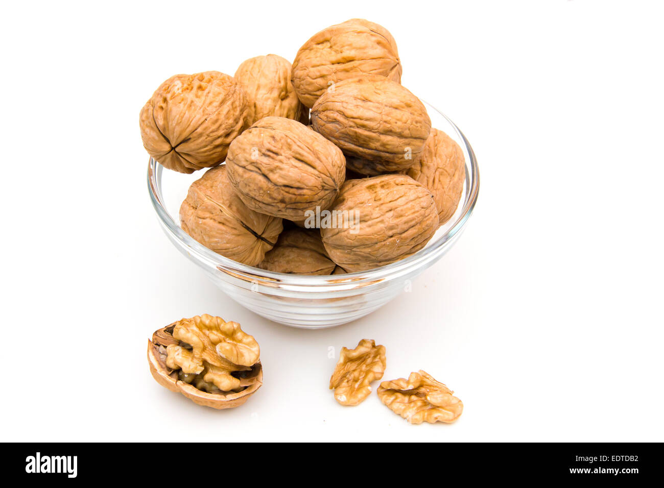 Bowl with unshelled walnuts on white background Stock Photo