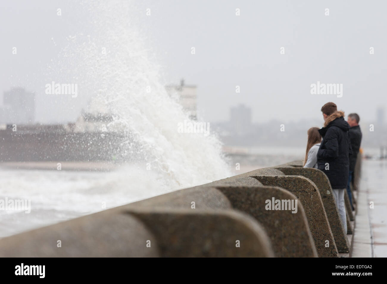 New Brighton, Merseyside, UK. 9th January, 2015.  People watch as waves crash onto New Brighton promenade in Merseyside. Credit:  Adam Vaughan/Alamy Live News Stock Photo