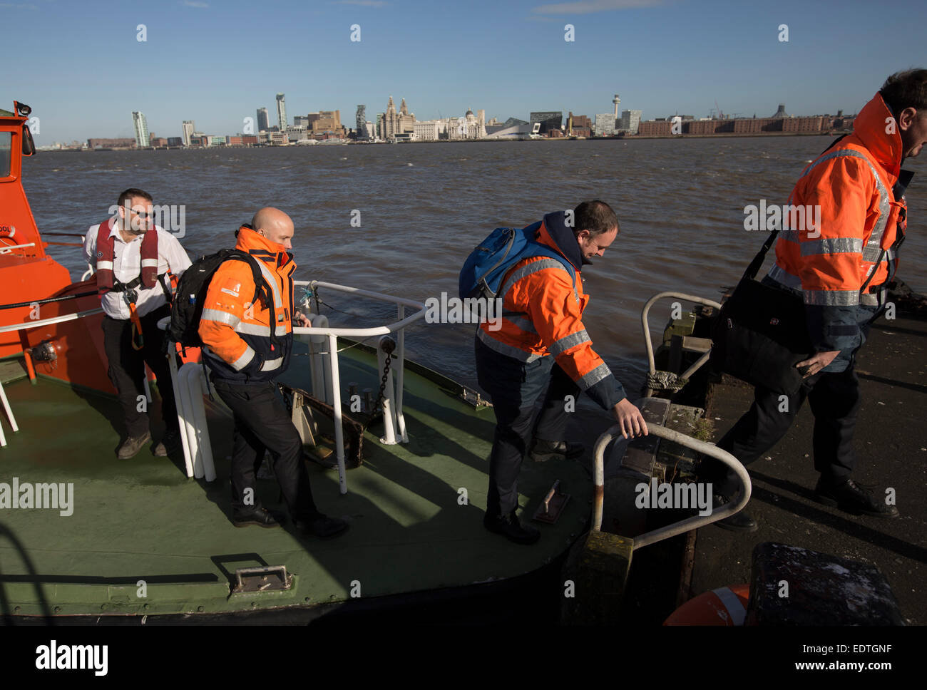 A team of Liverpool pilots employed by Liverpool Pilot Services Ltd on the river Mersey, England, disembark from a pilot launch. Stock Photo