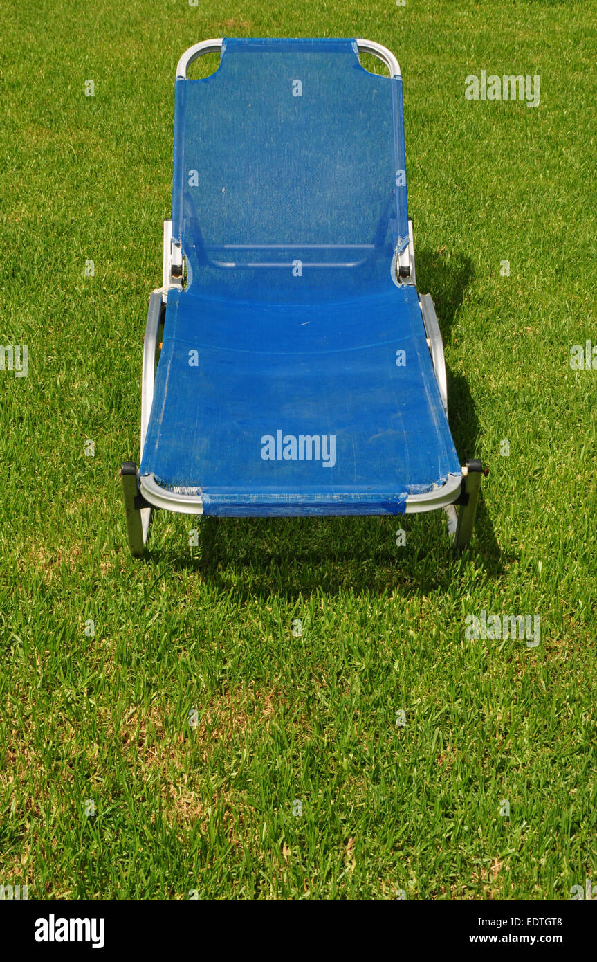 Reclining lawn chair on green grass background. Garden furniture. Stock Photo