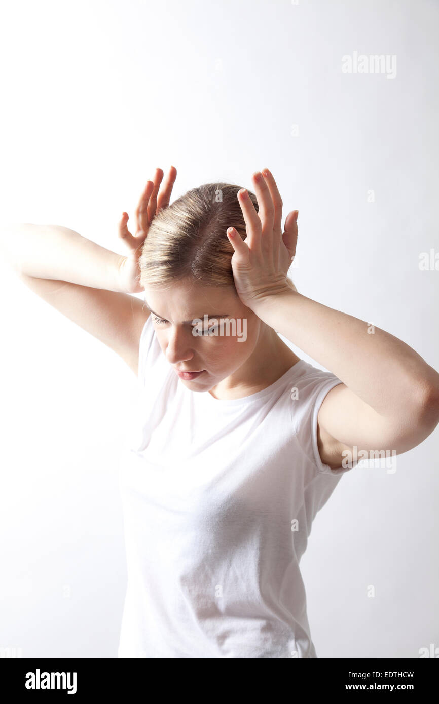 Woman in T-shirt Touching Head Stock Photo