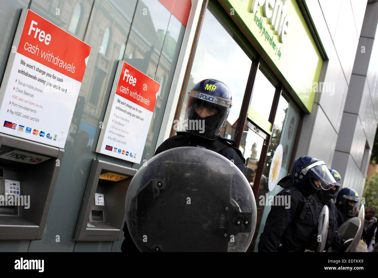Riot police guarding a bank and shops in Hackney during the 2011 riots Stock Photo