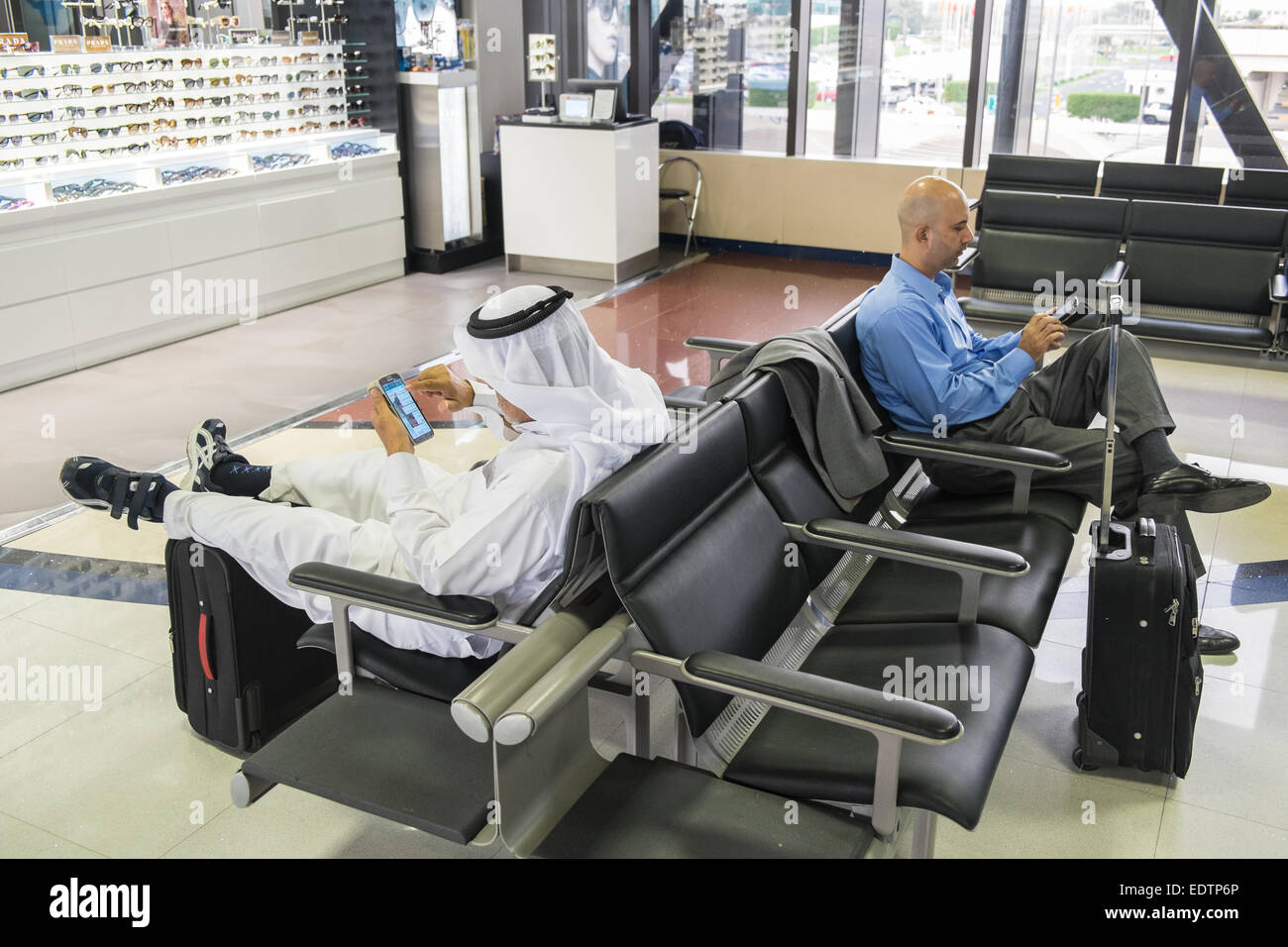 Using mobile phones at departure lounge at Bahrain International Airport, Bahrain, Middle East