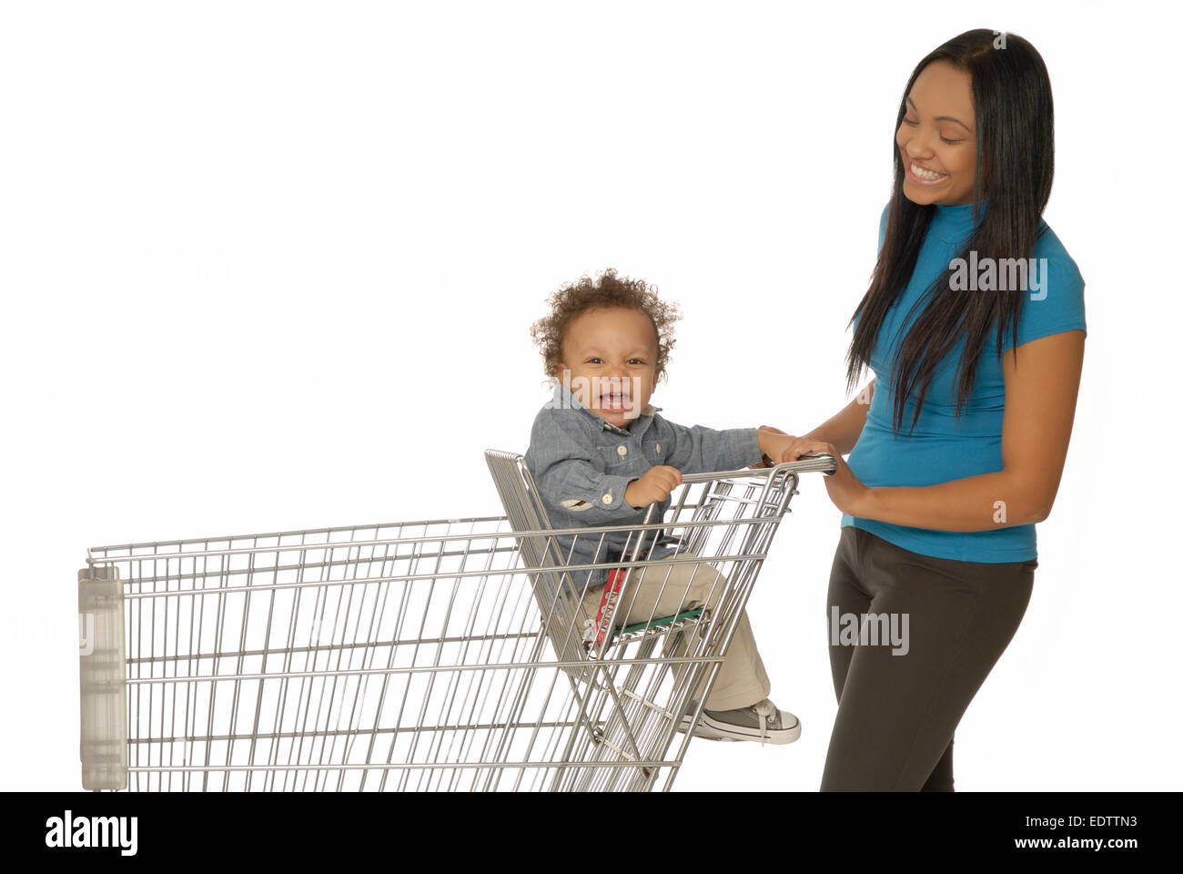 Attractive young mother with one year old son in shopping cart or ...