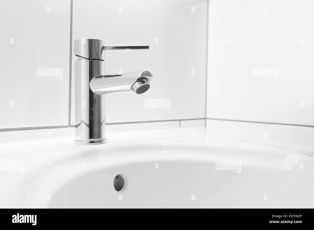 Faucet and white basin in a bathroom Stock Photo