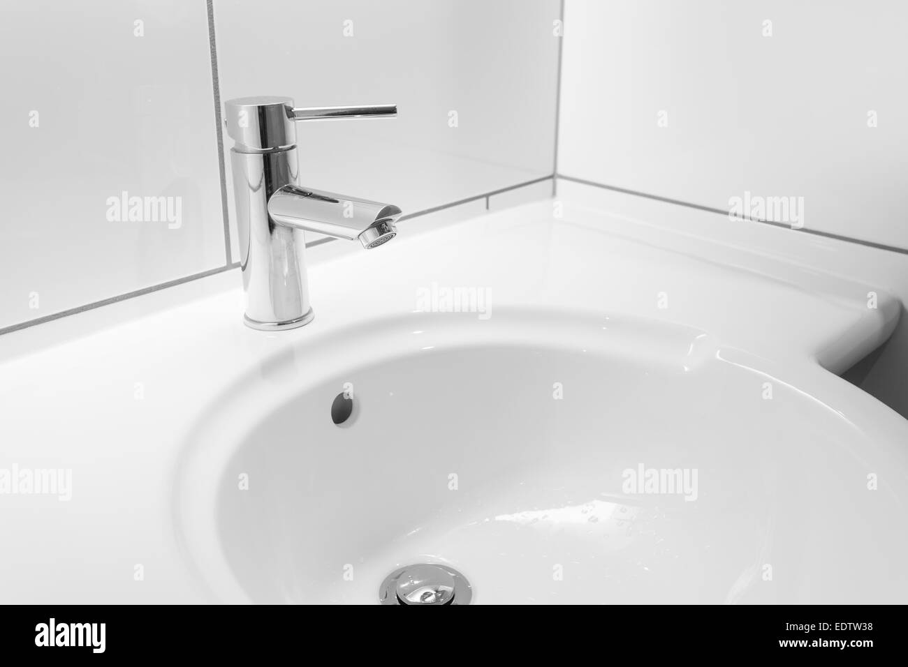 Faucet and white basin in a bathroom Stock Photo