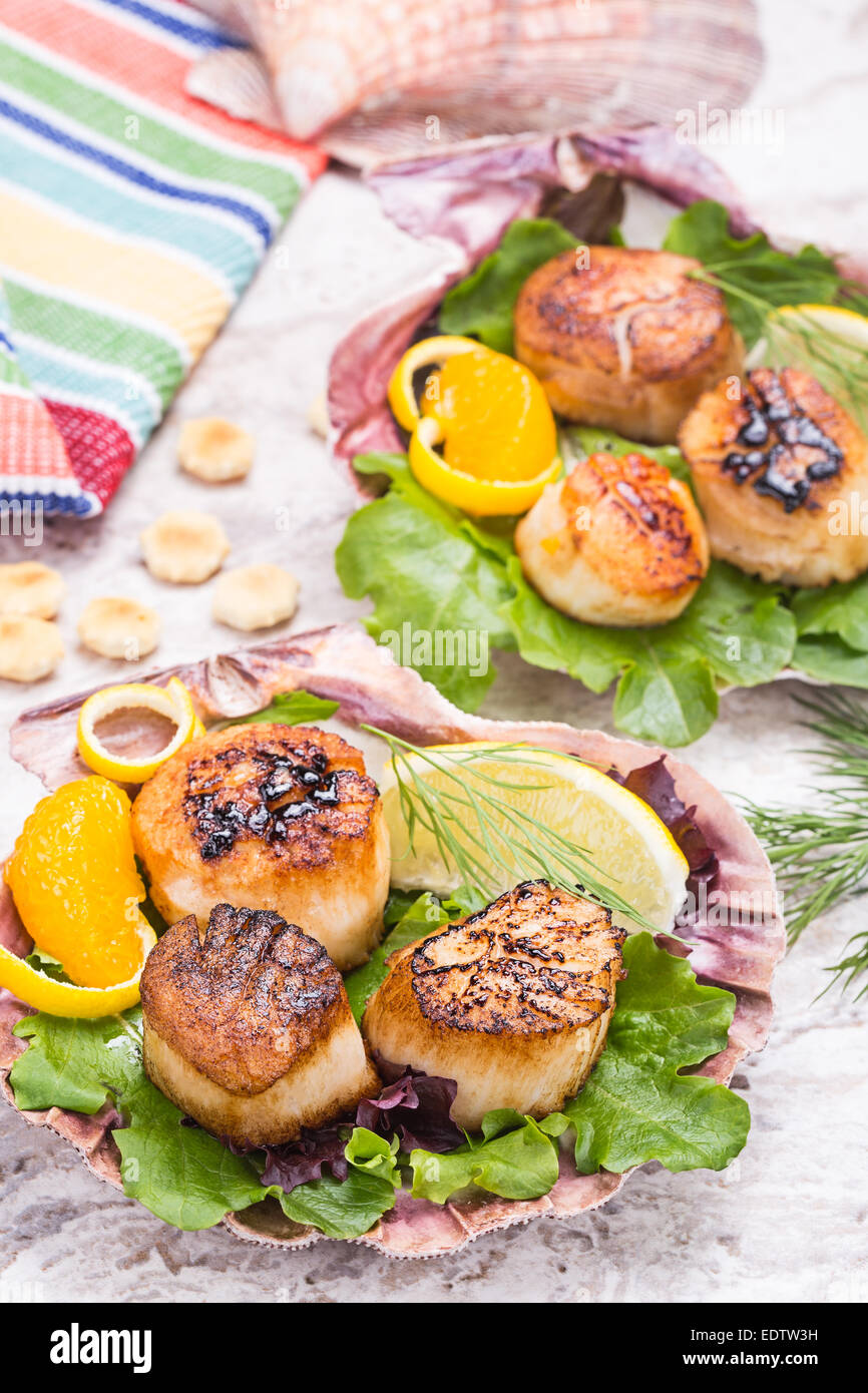 pan seared sea scallops on bed of baby greens presented in large