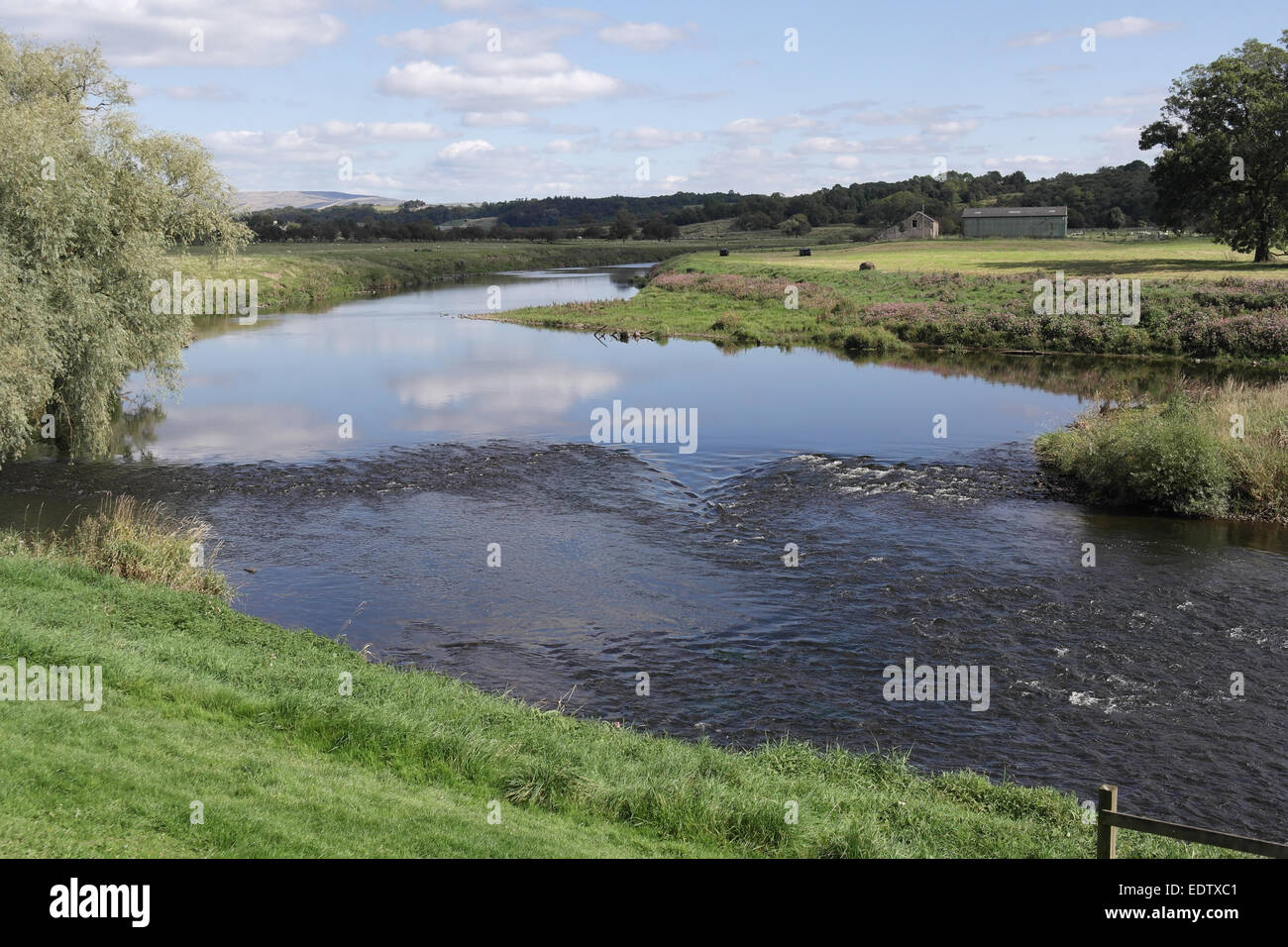 Blue sky white cumulus cloud views mall rapids in channel of River Ribble crossing rural landscape upstream of Ribchester, UK Stock Photo