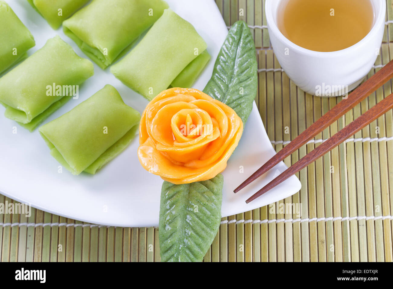 Close up top view horizontal image of Chinese Durian fruit dessert rice cakes, yellow decoration rose, and green tea Stock Photo